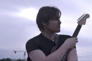Michael holding the guitar outside