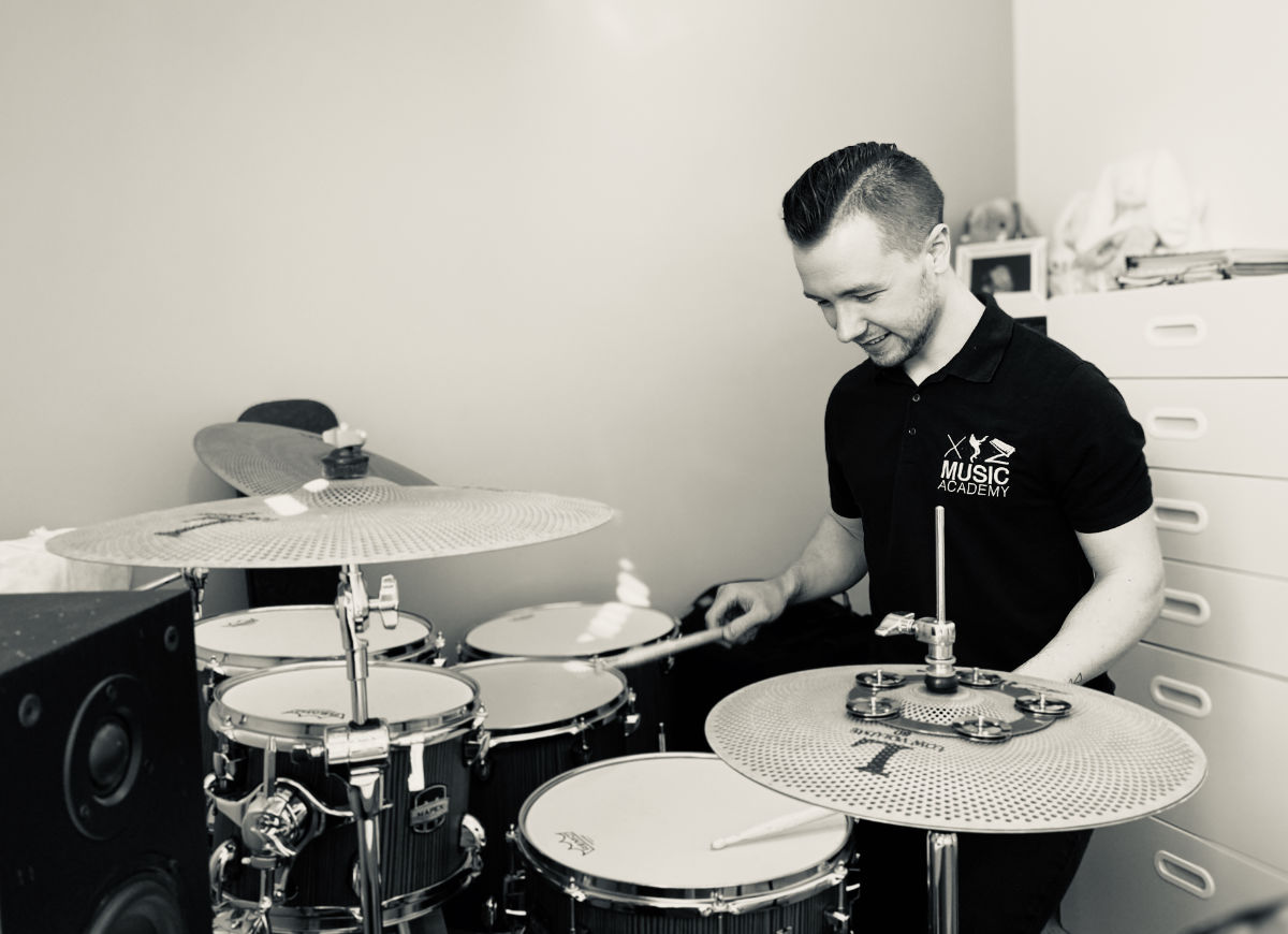 Richard playing the drums at home in black and white